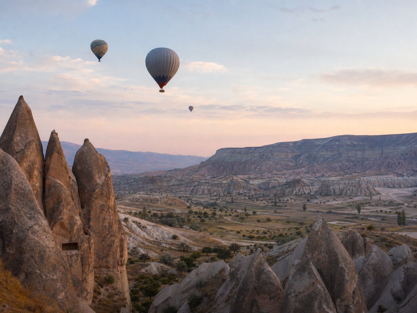 Hot-air balloons drifting above Cappadocia at dawn